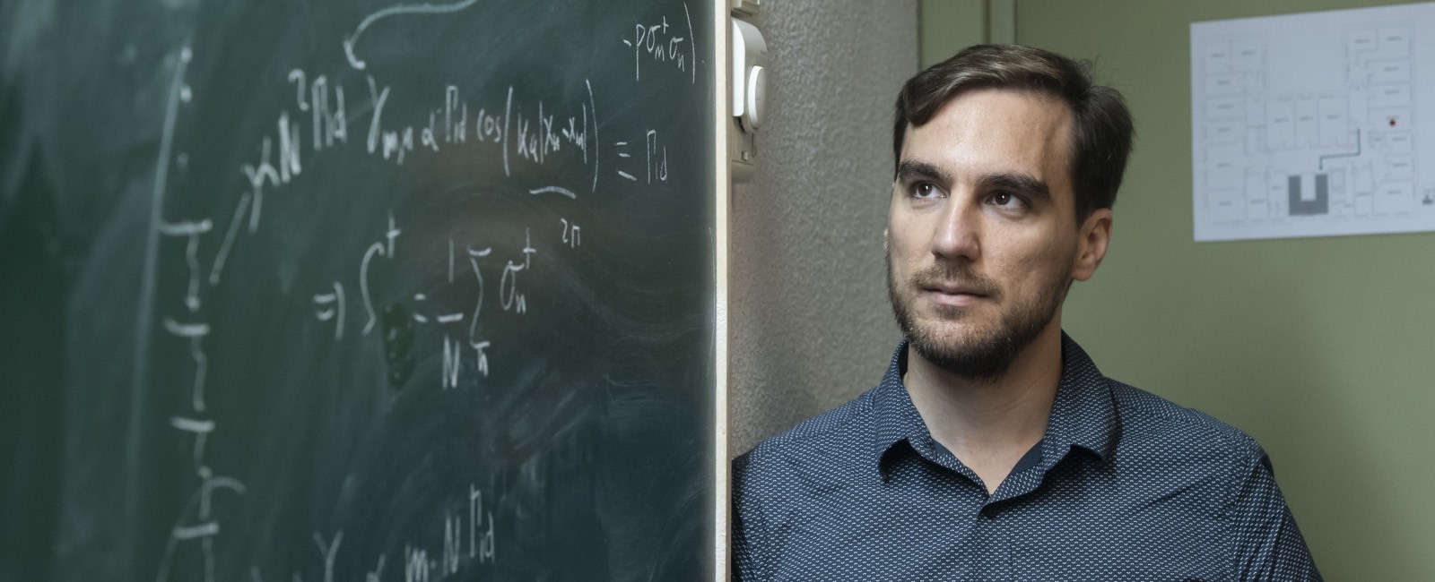 Alejandro González Tudela junto a una pizarra con fórmulas escritas a tiza
